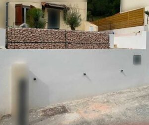 Aménagement d'un mur en gabion avec des pierres en gabion de marbre rose à Riboux