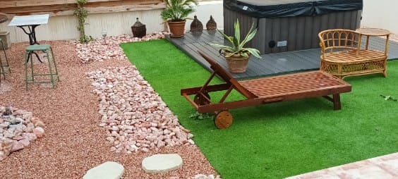 Réalisation d'un aménagement extérieur avec du gravier rose. et allée de galets